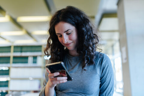 A young woman looking down at her smartphone